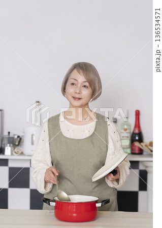 キッチンで作った料理の味見をするシニア女性 キッチンで作った料理の味見をするシニア女性 136534571