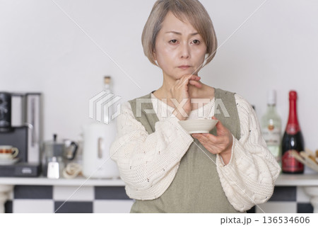 キッチンで作った料理の味見をするシニア女性 キッチンで作った料理の味見をするシニア女性 136534606