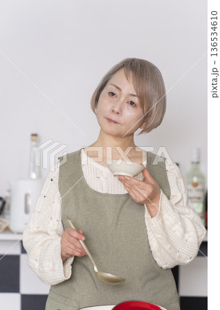 キッチンで作った料理の味見をするシニア女性 キッチンで作った料理の味見をするシニア女性 136534610