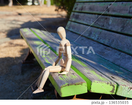 公園のベンチに座る一つの木製のマネキン人形の姿 公園のベンチに座る一つの木製のマネキン人形の姿 136535035