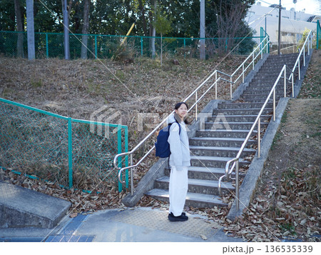 冬の昼の公園にいる一人の女子中学生の姿 136535339