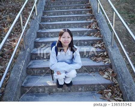 冬の昼の公園にいる一人の女子中学生の姿 冬の昼の公園にいる一人の女子中学生の姿 136535342
