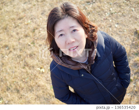 冬の午後の公園で散歩する中年女性主婦の姿 136535420