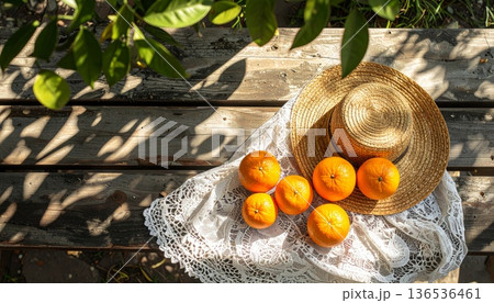 Orange with Straw Hat on Rustic Wooden Table 136536461
