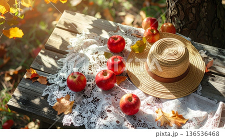 Red Apple with Straw Hat on Rustic Wooden Table in Autumn 136536468