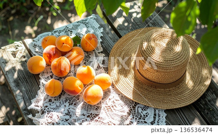 Apricots with Straw Hat on Rustic Wooden Table 136536474