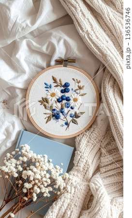 Embroidered Blueberry Hoop on Bed with Knitted Blanket Book and White Dried Flowers 136536746