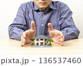 住宅模型を囲う男性 136537460