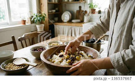 Hands Mixing Korean Yakbap Ingredients in Wooden Bowl Traditional Cooking Scene 136537667