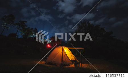 nature traveling with orange camping tent on mountain with milky way and star background 136537711