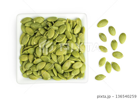 Peeled pumpkin seeds in ceramic bowl isolated on white background. Top view. Flat lay Peeled pumpkin seeds in ceramic bowl isolated on white background. Top view. Flat lay 136540259