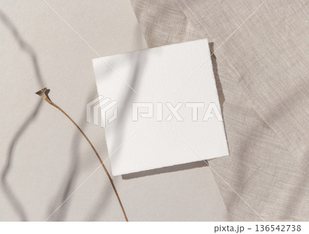 Blank paper card on natural beige stone and linen cloth with hard shadows, top view, boho mockup Blank paper card on natural beige stone and linen cloth with hard shadows, top view, boho mockup 136542738