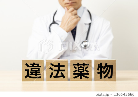 「違法薬物」と書かれたブロックと悩む医師 「違法薬物」と書かれたブロックと悩む医師 136543666