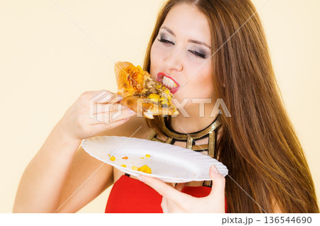 Woman eating hot pizza slice 136544690