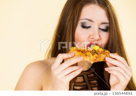 Woman eating hot pizza slice 136544691