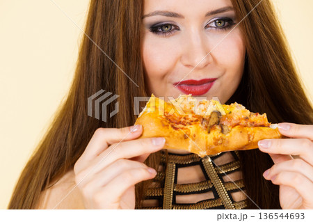 Woman eating hot pizza slice 136544693