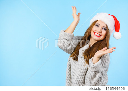 Woman in christmas santa hat on blue Woman in christmas santa hat on blue 136544696