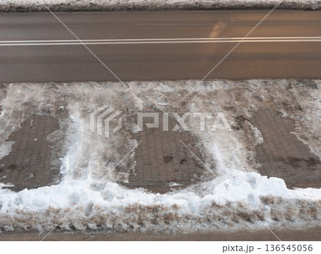 Empty parking places with snow at the asphalt road. Cars had just driven away. Winter urban landscape Empty parking places with snow at the asphalt road. Cars had just driven away. Winter urban landscape 136545056