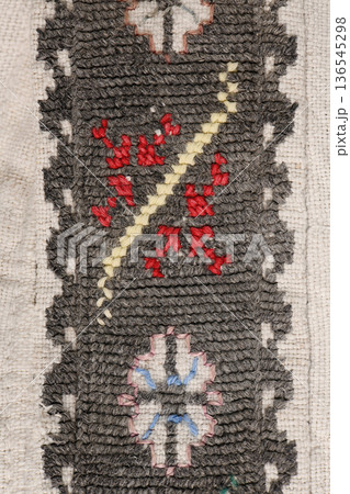 Dark grey woven fabric texture with red and white geometric embroidery Dark grey woven fabric texture with red and white geometric embroidery 136545298