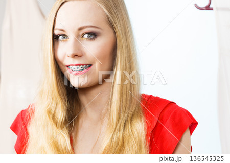 Happy smiling woman next to short white dress 136545325