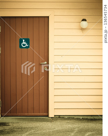 Blue handicapped wheelchair sign on door of public toilet Blue handicapped wheelchair sign on door of public toilet 136545734
