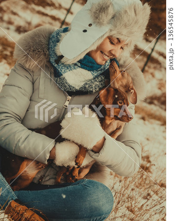 Woman playing with dogs during winter Woman playing with dogs during winter 136545876