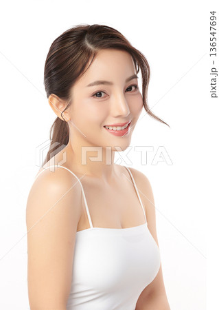 A beautiful young Asian woman with clean, fresh skin against a white background. Skincare, facial treatment, cosmetology, beauty, and spa. An elegant portrait of an Asian woman. 136547694