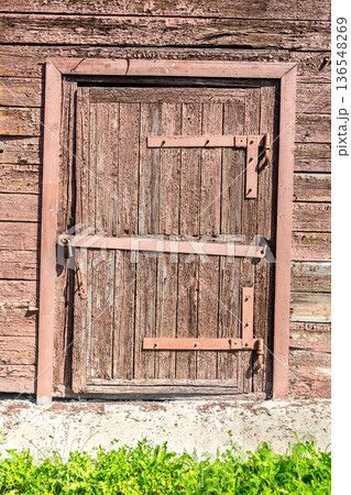 Old wooden door with metal padlock 136548269