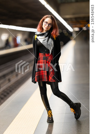 Young woman commuting, standing on urban subway platform Young woman commuting, standing on urban subway platform 136548483