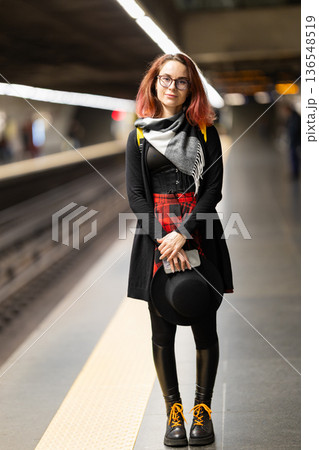 Young woman waiting on metro platform looking Young woman waiting on metro platform looking 136548519