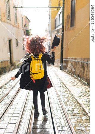 Traveler running with backpack on urban tram tracks Traveler running with backpack on urban tram tracks 136548564