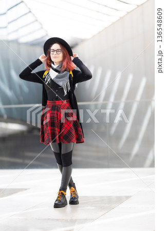 Young woman with red hair standing in urban setting Young woman with red hair standing in urban setting 136548609