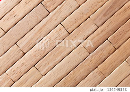 Close-up view of interlocking wooden blocks arranged in a geometric pattern, showcasing the natural grain and texture of the wood surface in a light color Close-up view of interlocking wooden blocks arranged in a geometric pattern, showcasing the natural grain and texture of the wood surface in a light color 136549358