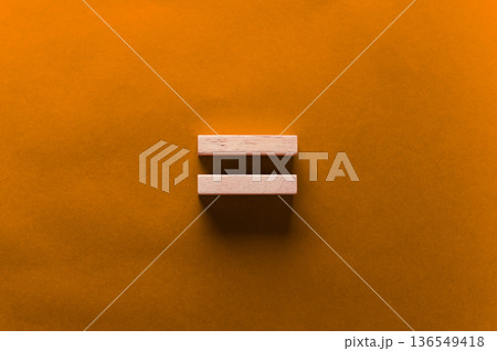 Two wooden blocks arranged horizontally on a vibrant orange background, showcasing a minimalist design with a focus on geometric shapes and color contrast Two wooden blocks arranged horizontally on a vibrant orange background, showcasing a minimalist design with a focus on geometric shapes and color contrast 136549418