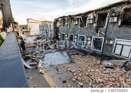 Bila Tserkva, Kyiv region, Ukraine 09.06.2025: Charred multi story building with broken windows, scattered debris, and intact air conditioners scene of localized fire damage amid urban surroundings. Bila Tserkva, Kyiv region, Ukraine 09.06.2025: Charred multi story building with broken windows, scattered debris, and intact air conditioners scene of localized fire damage amid urban surroundings. 136550005