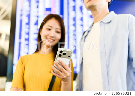 空港でスマホ確認する二人 ■撮影協力：関西国際空港（KIX） 136550321
