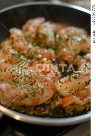 Shrimp saut ing in olive oil with garlic and parsley in a frying pan on the stove fresh, homemade seafood meal preparation Shrimp saut ing in olive oil with garlic and parsley in a frying pan on the stove fresh, homemade seafood meal preparation 136550779