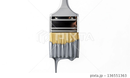a paintbrush is partially dipped in gray paint, with drips of paint hanging from the bristles 136551363