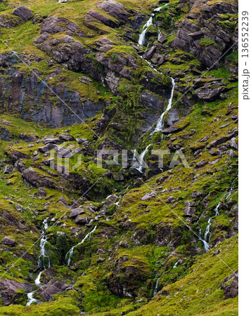 The sound of water echoes through the natural terrain. Natures artwork, water carving through green and stone. The sound of water echoes through the natural terrain. Natures artwork, water carving through green and stone. 136552239