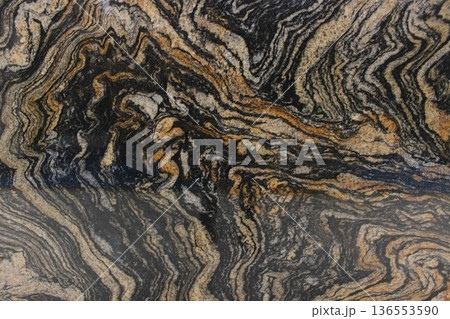 Magma Gold granite texture from Brazil with dramatic black and gold wave patterns, suitable for luxury interior design. Magma Gold granite texture from Brazil with dramatic black and gold wave patterns, suitable for luxury interior design. 136553590