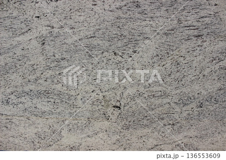 Detail of white granite texture with evenly distributed small grey mineral grains, durable natural stone for exterior floors and walls. Detail of white granite texture with evenly distributed small grey mineral grains, durable natural stone for exterior floors and walls. 136553609