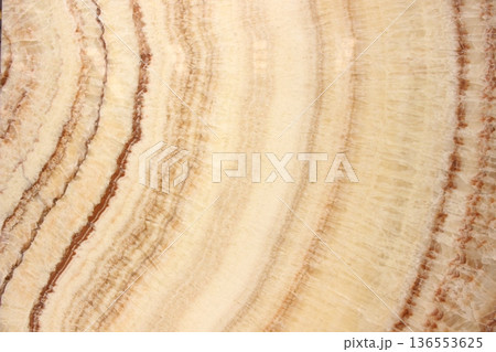 Honey Onyx marble texture with concentric circular patterns and warm orange and beige color gradations. 136553625