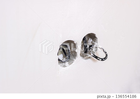 Scene showing incomplete drywall work with dangling wires and aged plaster details Scene showing incomplete drywall work with dangling wires and aged plaster details 136554186