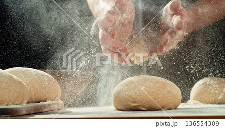 Chef Clapping Flour-Covered Hands. Flour Explosion During Yeast Dough Preparation, Baking Concept on Dark Background 136554309