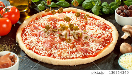 Closeup of black olives falling onto fresh pizza with tomato sauce, mozzarella and ham. Dynamic food motion highlights texture, freshness and Italian pizza preparation concept. Closeup of black olives falling onto fresh pizza with tomato sauce, mozzarella and ham. Dynamic food motion highlights texture, freshness and Italian pizza preparation concept. 136554349