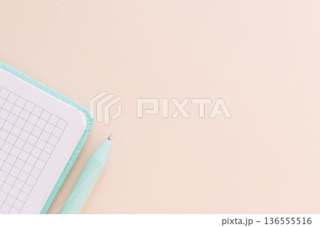Corner of grid notebook and pen on beige background with large copy space 136555516
