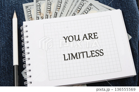 YOU ARE LIMITLESS is clearly written on a grid paper notebook page. A white pencil rests near the spiral binding 136555569