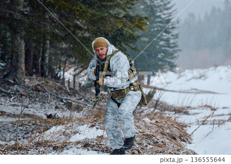 Soldier In White Winter Camouflage Patrolling Snowy Forest With Rifle And Tactical Gear Soldier In White Winter Camouflage Patrolling Snowy Forest With Rifle And Tactical Gear 136555644