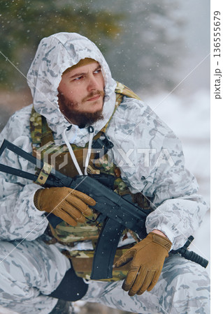 Winter Soldier In White Snow Camouflage Holding Rifle During Tactical Patrol In Forest Winter Soldier In White Snow Camouflage Holding Rifle During Tactical Patrol In Forest 136555679