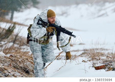 Soldier In Winter Camouflage With Rifle Patrols Snowy Mountain Terrain During Cold Weather Operations 136555694